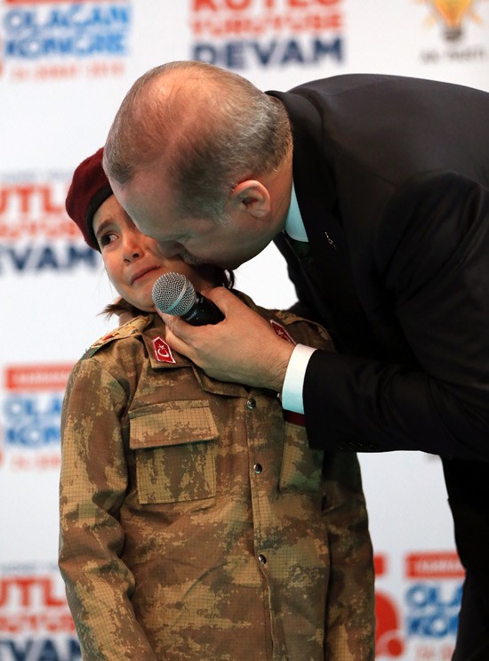 土耳其總統艾爾段（右）出席活動時，邀穿軍裝的小女孩上台，嚇哭小女孩。   圖：翻攝土耳其政府官網