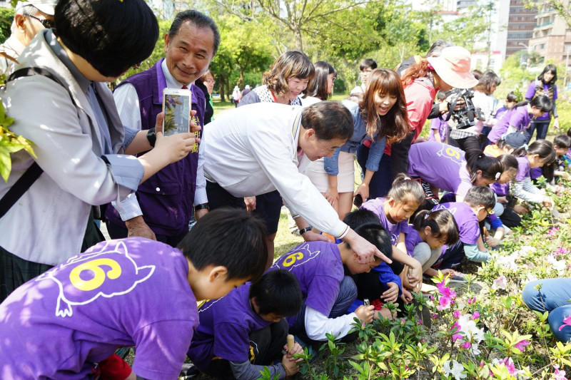 台北市副市長陳景峻今天和龍安國小學生一同親手種杜鵑花，「以花代樹」，小朋友都感到新鮮有趣   圖：台北市政府/提供