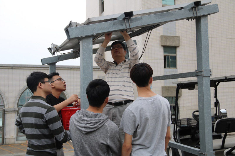 助理教授嚴坤龍（中）向學生解說太陽能光電設備拆卸要領。   弘光科大/提供