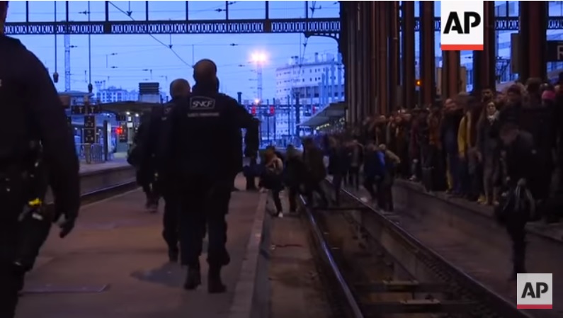 因法國國鐵員工罷工，火車站內出現民眾跨越鐵軌現象。   圖：翻攝youtube
