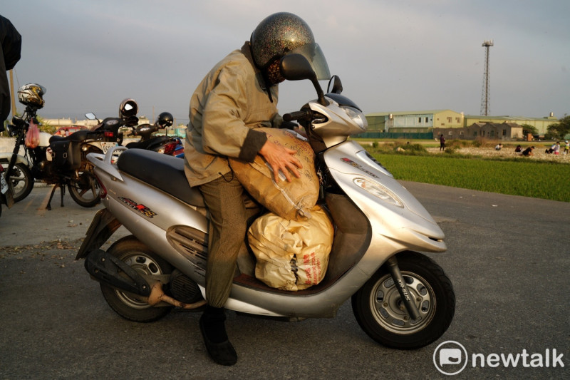 一位阿嬤揀了兩大袋免錢洋蔥，塞爆摩托車的踏板。   圖：張良一/攝