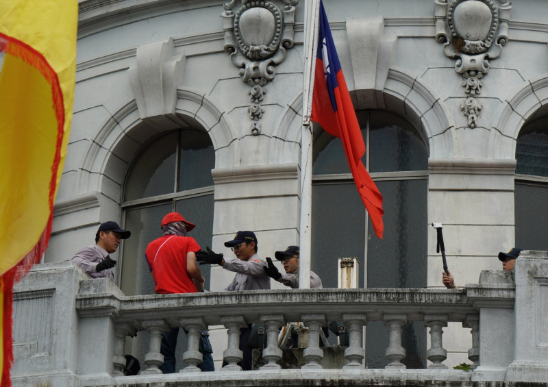 民眾爬上監察院揮舞國旗，隨後警方向前制止。   圖：張良一/攝