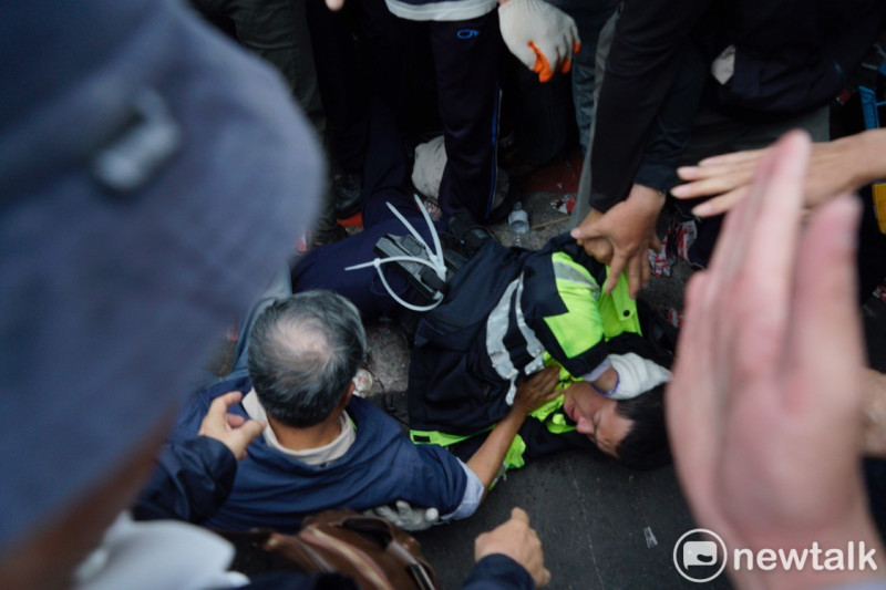 反年改團體與警方爆發嚴重衝突，一名員警被拉倒在地。   圖：張良一／攝