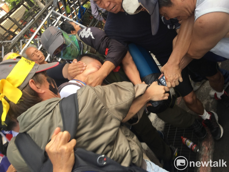 民報記者鍾孟軒25日下午被反年改團體圍毆，搶奪相機。   圖：黃韋銓/攝