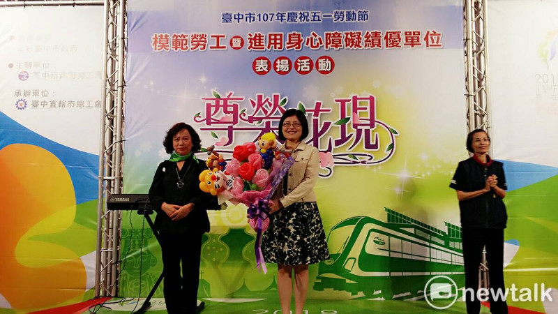 江春瑟代表勞工朋友獻上氣球花束給勞工局長黃荷婷。   唐復年/攝