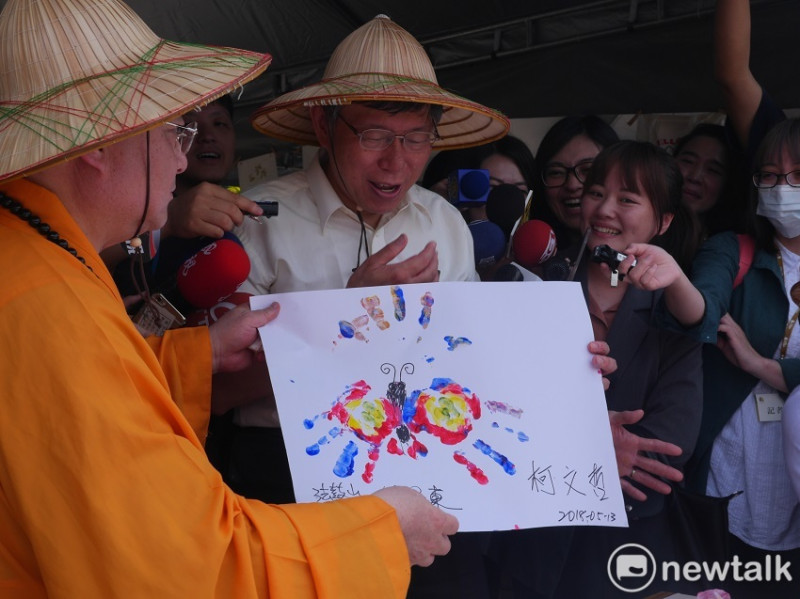 台北市者柯文哲今（13）天出席法鼓山舉辦的「心靈環保家庭日」活動，柯也將顏料沾在手上，創作一幅蝴蝶的手印畫。   圖：趙婉淳／攝