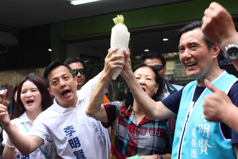 前總統馬英九（右）20日上午陪同參選台北市南港內湖區議員的李明賢（左2）到市場拜票，民眾贈送菜頭祝福選情。   圖：中央社