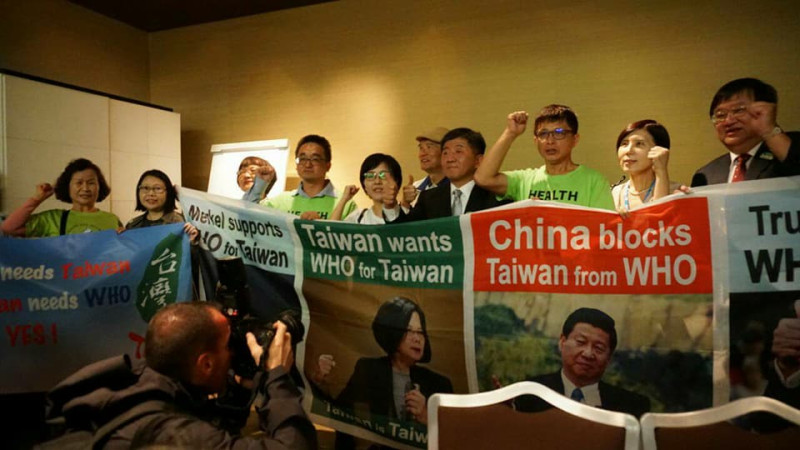 陳時中(中)於國際記者會現場與出席會眾合影，並對台灣未受邀出席WHA表達抗議與不滿。   圖：外交部／提供