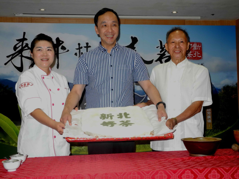 朱立倫與台灣蛋糕協會副會長陳郁芬（左）一同示範手作「包種茶髒髒包」，從磨茶粉、灑糖霜到完成髒髒包，一氣呵成。    圖：王峻昌/攝