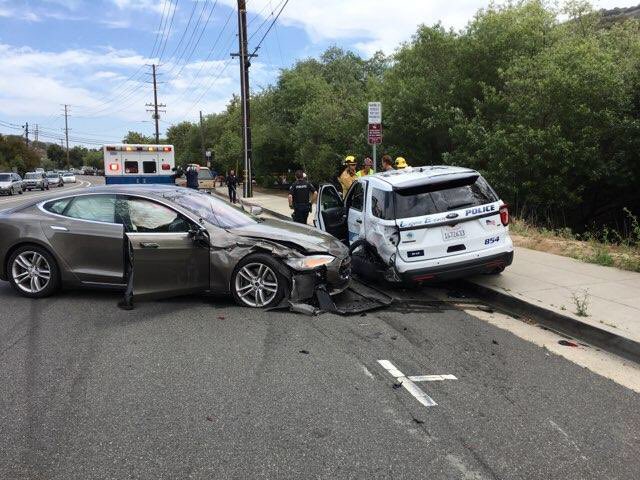 美國加州29日發生特斯拉汽車（左）撞上停在路旁的警車意外，所幸駕駛只受輕傷。   圖：翻攝加州拉古納海灘警察隊長推特