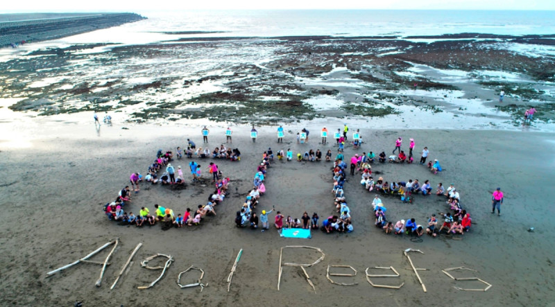 搶救大潭藻礁行動聯盟去年6月8日搶在海岸以「國際海洋日 藻礁有喜事」的心境排出SOS圖形空拍，讓搶救大潭藻礁十萬火急的訊息被廣為周知。   圖：搶救大潭藻礁行動聯盟/提供