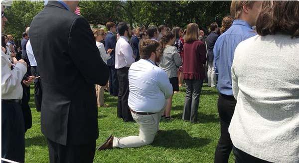 白宮草坪前，一男子單膝跪地聽總統川普講話，但不是在向女友求婚，而是在抗議川普對非裔球星的種族歧視言論。   圖：翻攝自澎湃新聞