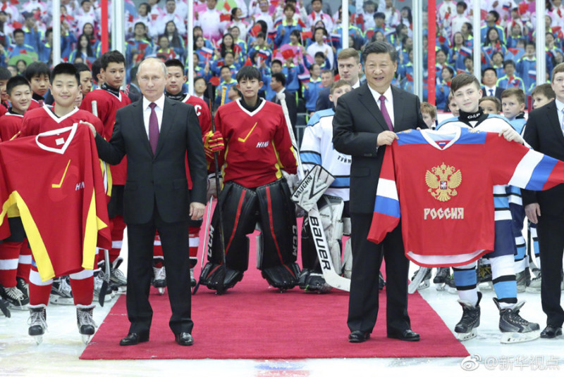 中國國家主席習近平8日晚間與俄羅斯總統蒲亭會談後，在天津體育館共同觀看中俄青少年冰球友誼賽，為比賽開球，並與小隊員們交談、合影。   圖：翻攝自新華網