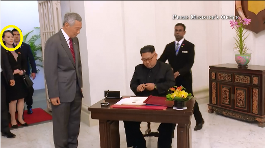新加坡總理李顯龍（中著灰衣者）歡迎金正恩（右坐者）到訪，而金與正（圓圈處）低調現身門外。   圖：翻攝李顯龍臉書