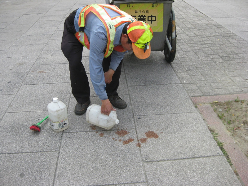 清潔人員清洗水泥磚上的檳榔漬。   圖 : 高雄市環保局/提供