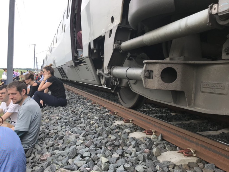 上百名歐洲議會議員與工作人員11日在前往斯特拉斯堡途中，搭乘的Thalys特快列車突然因斷電而停駛，坐在鐵軌上枯等。   圖：翻攝歐洲議會成員Terry Reintke推特