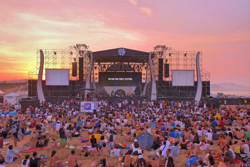 民眾在夕陽下坐在舞台前欣賞新北市貢寮國際海洋音樂祭。   圖 : 新北市政府/提供