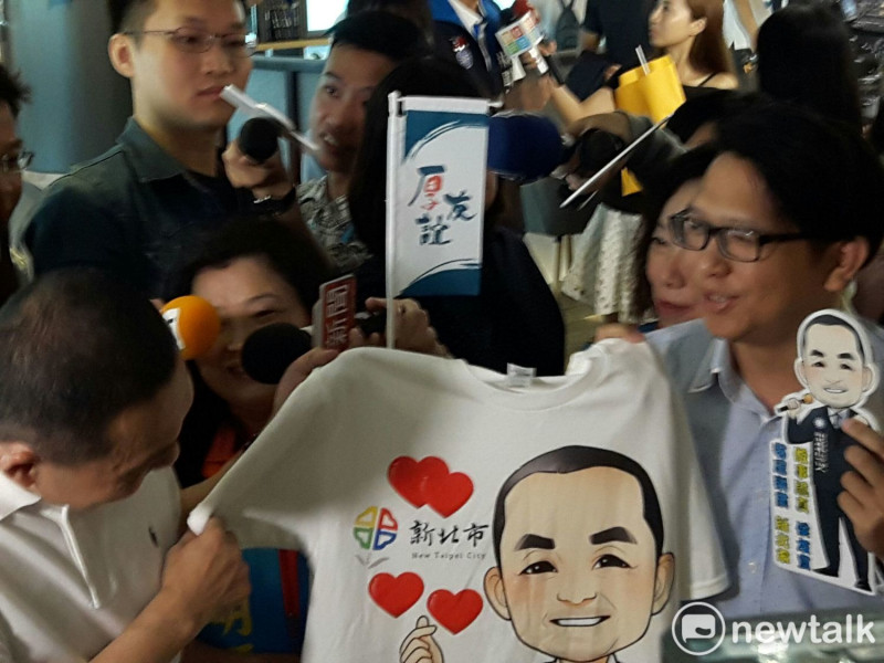 支持民眾拿著自己設計的競選T恤要送給侯友宜。   圖：林昀真/攝