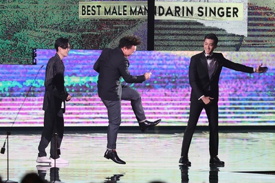 第29屆金曲獎頒獎典禮23日晚間在台北小巨蛋舉行，香港歌手陳奕迅（中）第3度奪得最佳國語男歌手獎，在台上開心躍起。左為頒獎人方大同。   圖：中央社