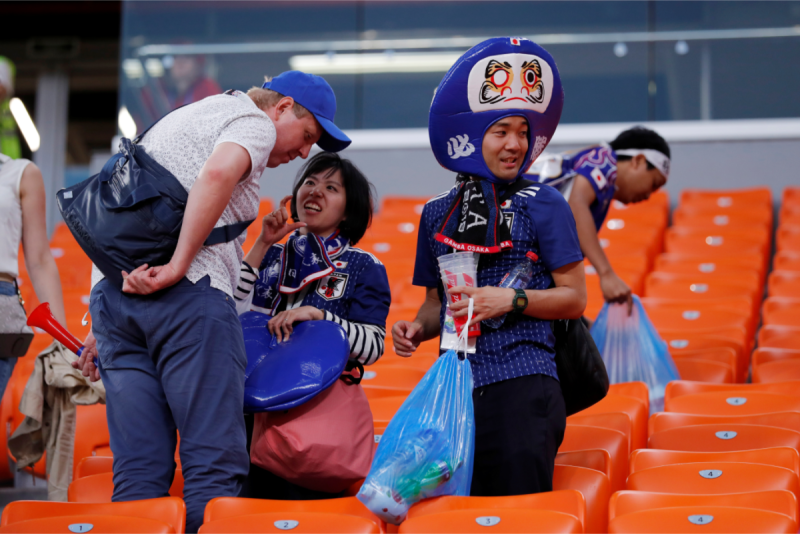 比賽結束，日本球迷隨手把座位附近的垃圾整理好帶走。   圖：達志影像/路透社
