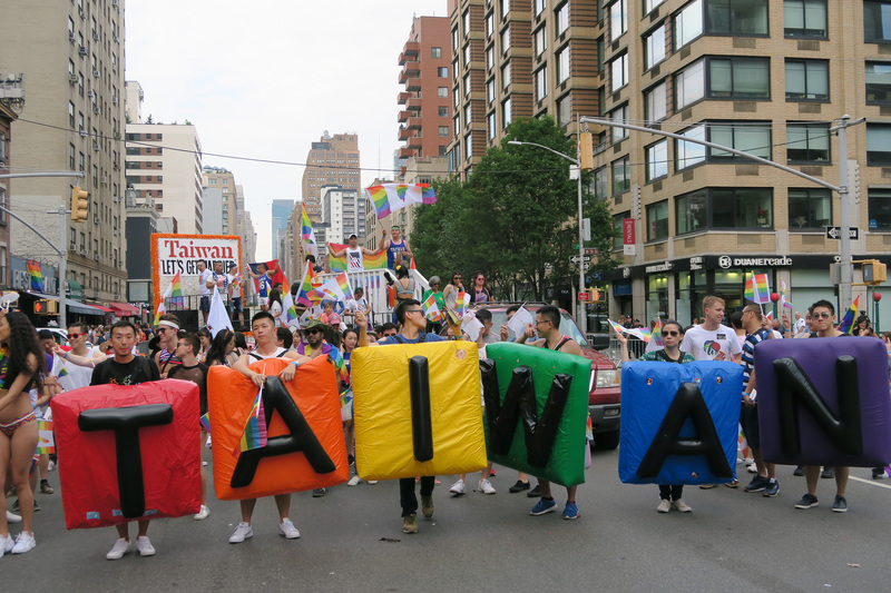紐約市驕傲遊行美東時間24日登場，台灣花車連續第3年參加，100多人高舉彩虹旗同歡，隊伍前面用彩虹色充氣墊排成TAIWAN字樣，十分醒目。   圖/中央社