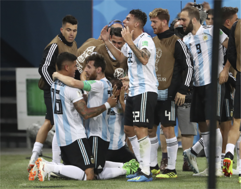 梅西自2014年世足賽接任阿根廷國家足球隊隊長至今，本屆已連任一次。在這次小組賽前兩場踢完，戰績一和一負，正瀕臨淘汰邊緣。圖為阿根廷在台北時間27日凌晨以2：1力克奈及利亞，驚險晉級16強後，阿根廷球員圍繞著隊長梅西（左2跪地者），一起歡欣慶祝勝出的鏡頭。   圖：達志影像/美聯社