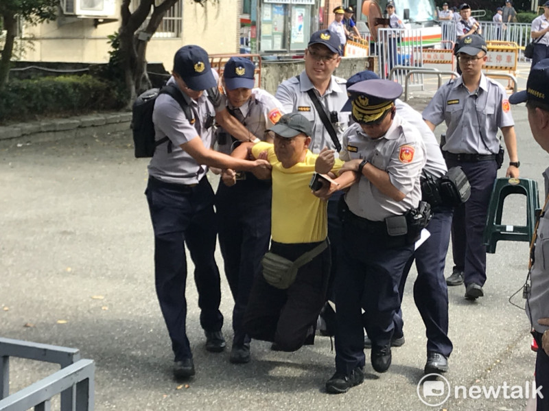 一位自稱退伍軍人的抗議民眾遭警方抬進意見表達區。   圖 : 周煊惠 / 攝