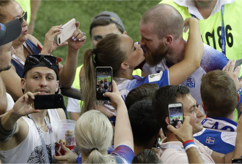 6月27日，俄羅斯世界盃足球賽D組小組賽第3輪，冰島最後以1：2一球之差小輸強敵克羅埃西亞。賽後，冰島球迷圍繞著球員為他們加油打氣，並紛紛興奮地自拍了起來。中場右後衛Aron Gunnarsson更與女友當場親吻放閃，成了旁人鏡頭捕捉的焦點。   圖：達志影像/美聯社