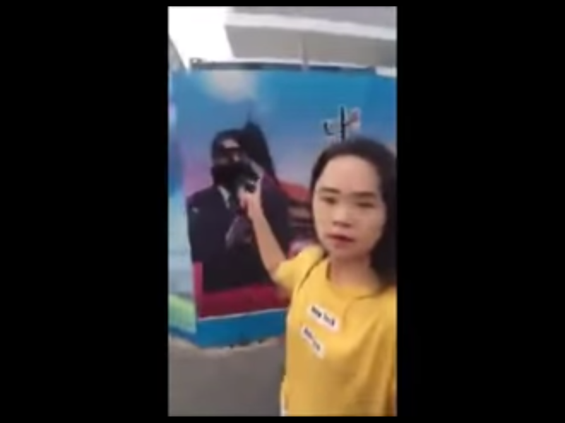 董女以「行為藝術」為名，向「中國夢」宣傳海報上的中國國家主席習近平畫像潑墨。   圖：翻攝自Youtube