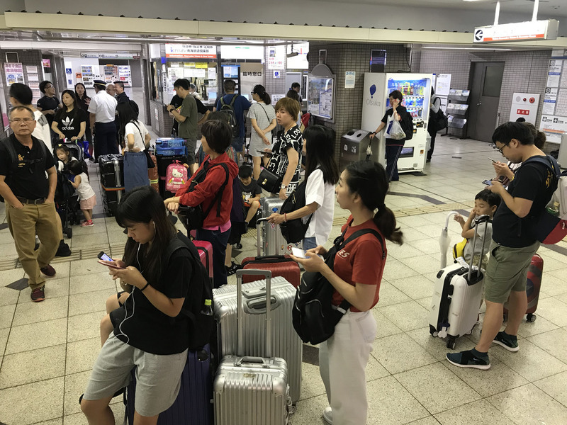 日本關西地區遭遇「歷史性」豪雨襲擊，部分電車鐵道停駛，大批旅客6日在大阪市天下茶屋站內滯留，等待發車。   圖/中央社