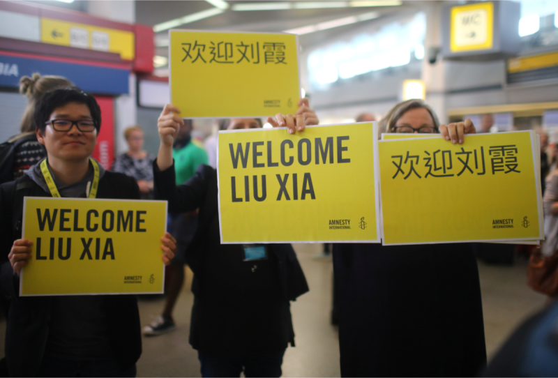 手持「歡迎劉霞」中英文標語的維權人士，在機場迎接劉霞，祝賀她重獲自由。   圖：達志影像/路透社