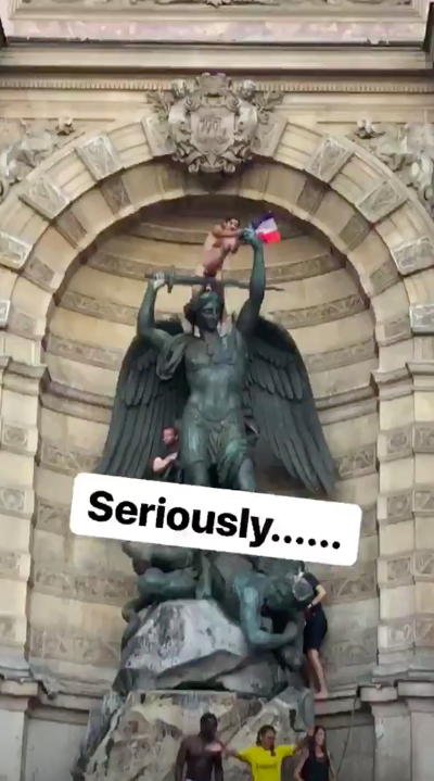 熱情球迷嗨過頭，爬上法國街頭雕像搖旗歡呼。   圖：翻攝自ＩＧ