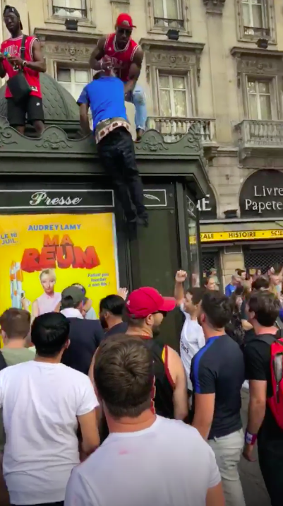 法國球迷踩街慶祝奪冠，爬上屋頂歡呼。   圖：翻攝自ＩＧ