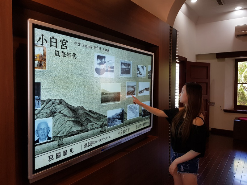 淡水古蹟博物館今年(107)將內部展區升級，運用互動多媒體及藝術畫將科技與美學導入歷史場域中，以超大觸控式螢幕呈現海關與小白宮從古到今的照片。   圖：淡水古蹟博物館提供
