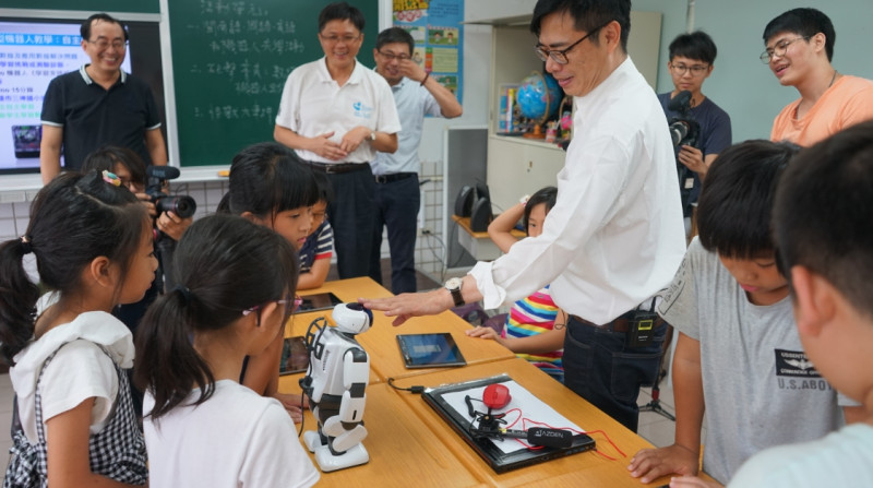 陳其邁與孩子們共同體驗台語及數學的數位課程教學活動，在機器人小老師的協助下，共同闖關解題。   圖/陳其邁辦公室