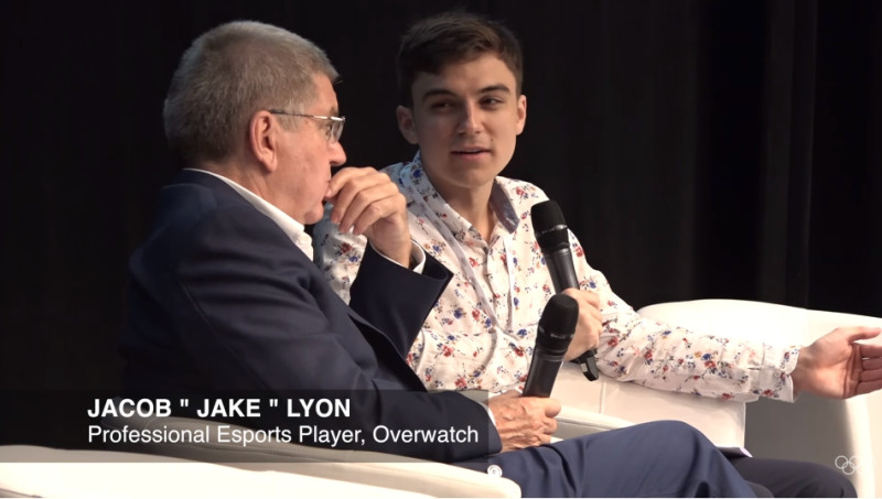 《鬥陣特攻》職業電競聯賽「休士頓神槍手」戰隊職業選手，本名Jacob Lyon的「Jake」坐在國際奧會主席巴赫發表談話。   圖：翻攝自 IOC Media YouTube