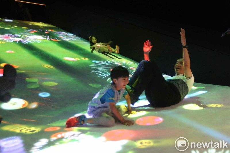 新北市長朱立倫在「2018新北市兒童藝術節」的《滑梯水果園》裝置，與小朋友一起玩到四腳朝天。                       
   圖：王峻昌/攝 