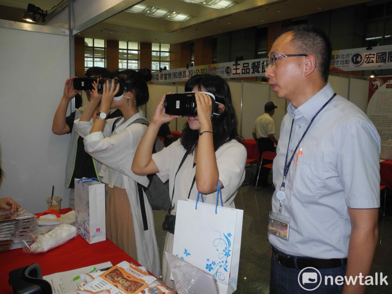 「2018新北市現場徵才活動」有新北首創的「VR 科技虛擬實境求職體驗」，就服處長林澤州 (右)在旁解釋。
   圖：王峻昌/攝