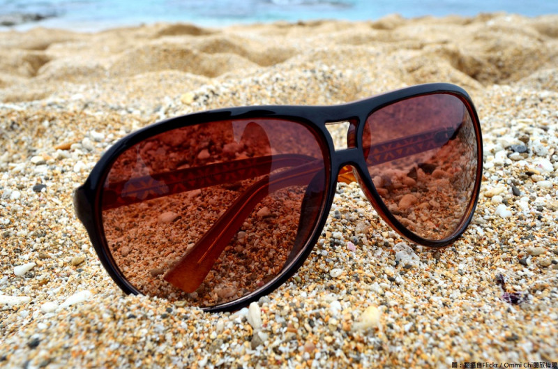 高溫悶熱天氣，外出配戴太陽眼鏡已成為基本防曬工具，但其實挑選墨鏡並非鏡片顏色愈黑、價格愈貴，功效就愈好。   圖：翻攝自Flickr／Ommi Chi開放權限