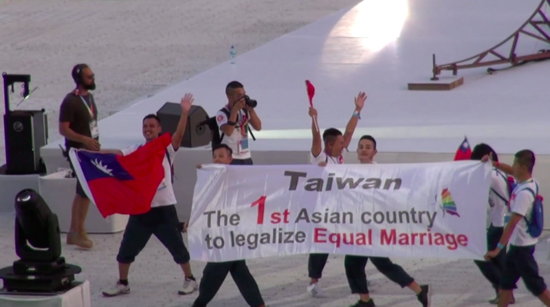 巴黎同志運動會揭幕，在開幕遊行中，台灣隊帶著國旗上場，還有一塊長布幅以英語寫著「台灣，第一個婚姻平權合法的亞洲國家」。   圖：中央社