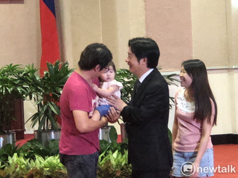 行政院長賴清德合影前先把幼兒從爸爸手中抱入懷裡。   圖：謝莉慧/攝