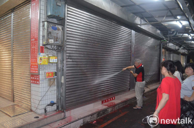 嘉義市噴水雞肉飯創始店12日晚間遭人潑漆，工作人員忙著清洗。   圖：蔡坤龍/攝