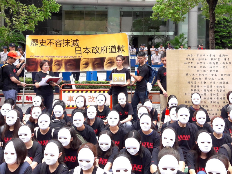 59名身穿黑衣，臉上戴著白色面具的民眾於今(14)日齊聚日本台灣交流協會前，以靜坐8分14秒的方式，來紀念814的國際「慰安婦」紀念日，同時對日本政府表達最沉重而無言的抗議。   圖：婦女救援基金會/提供