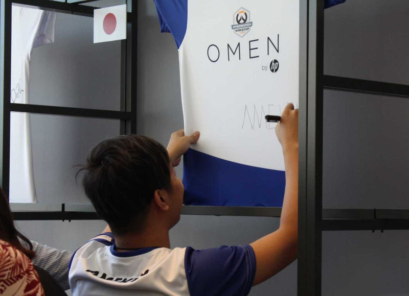 日本選手在幫樣品衣簽名。