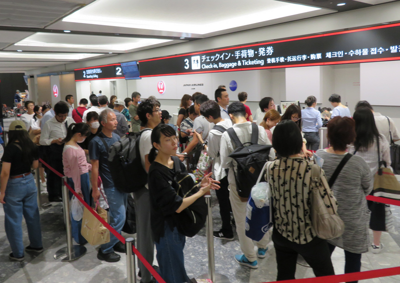 北海道6日凌晨觀測到強震，新千歲機場一度關閉，7日重啟部分國內線航班，許多旅客在櫃檯前等待購買機票。   圖：中央社