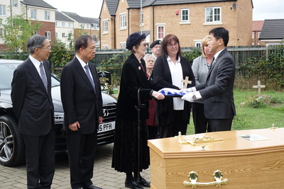 英國老兵費茲派翠克葬禮20日在英國里茲舉行，完成他以中華民國國旗覆棺的遺願後，國旗交給遺孀。   圖：中央社
