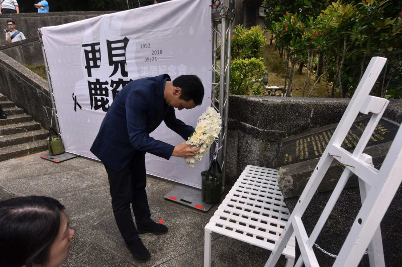 新北市長朱立倫為鹿窟事件受難者默哀，並向逝去的故人獻上白玫瑰花。   圖：新北市政府提供