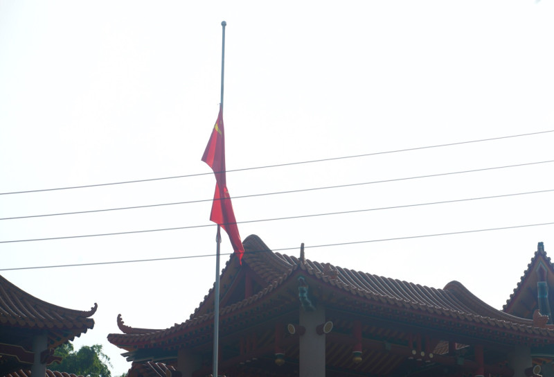 魏明仁在清晨7:56舉行降五星旗儀式，隨後並將碧雲禪寺正前方的四面五星旗和解方軍旗收下捲起來（4）。   圖：張良一/攝