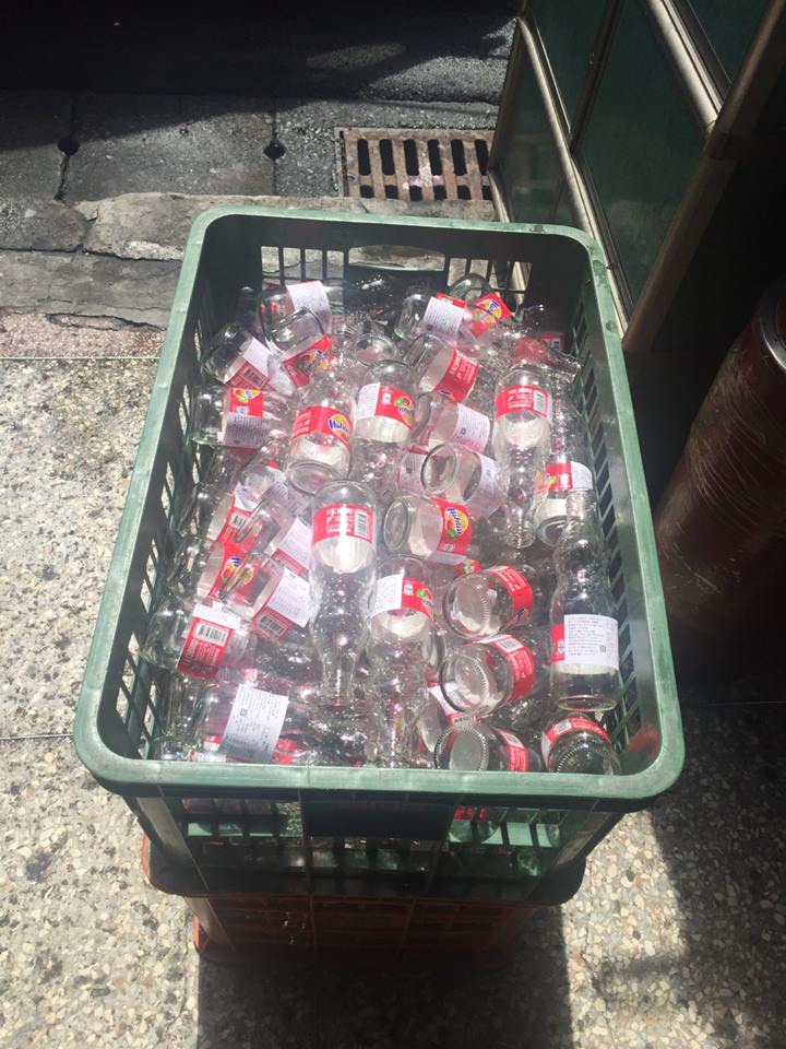 義工將飲品倒掉，整理成可回收的玻璃瓶。   圖：翻攝人安基金會-基隆平安站瞼書