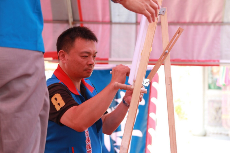 國民黨台南巿長候選人高思博在慶安宮前簽署「大台南經濟新政宣誓書」。   圖：黃博郎/攝